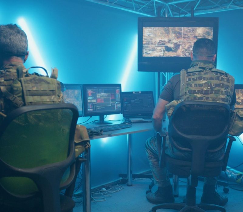 Insides of hidden intelligence base of United States with computers and guarding soldier at entrance in night